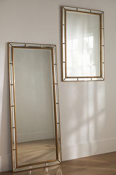 a mirror sitting on top of a wooden floor next to a wall