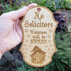 a person holding up a wooden sign that says no solicitors will be fixed