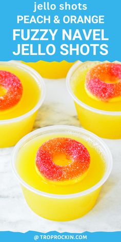 four orange jello shots in plastic cups with sprinkles on the top