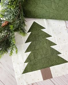 a green christmas tree pillow sitting on top of a wooden table