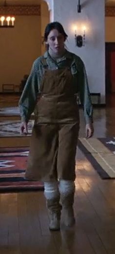 a man walking down a hall in front of a clock