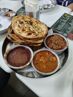 a plate with several different types of food on it, including pita bread and sauces