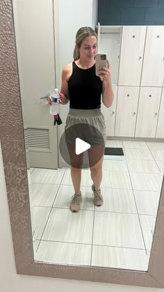 a woman taking a selfie in front of a mirror