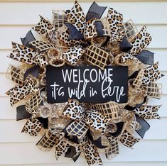 a leopard print wreath with the words, welcome to wild in life on it's side