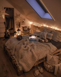 an attic bedroom is decorated with lights and blankets