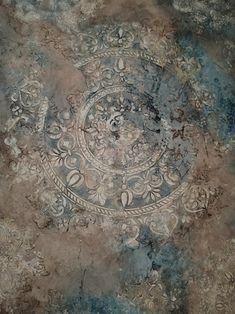 an artistic painting on the ground with blue and brown colors, including swirls and flowers