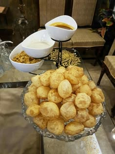 some food is on a glass table with two bowls and one bowl filled with sauce