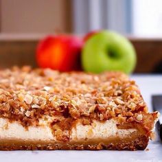 a piece of cake sitting on top of a table next to some apples and a knife