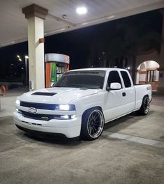 a white truck parked in front of a gas station