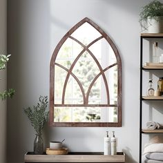 a bathroom with a large arched window above the sink and shelves on either side of the wall