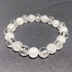 Embrace the beauty and energy of crystal-clear clarity with our stunning Clear & Crackle Quartz Gemstone Bracelet. This elegant piece features a harmonious blend of smooth, translucent clear quartz beads paired with eye-catching crackle quartz beads that shimmer with inner fractal patterns. Features: - Durable stretch cord - Genuine 8mm clear quartz beads - Genuine 8mm crackle quartz beads - Handcrafted with attention to detail - Bracelet length options from 6 to 8 inches Clear quartz is known a Crackle Quartz, Fractal Patterns, Gemstone Jewelry Handmade, Quartz Beads, Nature Bracelets, Beaded Stretch Bracelet, Jewelry Handmade, Gemstone Bracelet, Stretch Bracelet