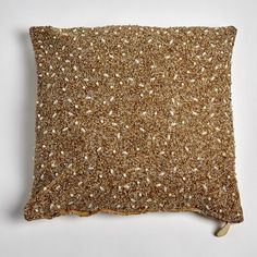 a pillow with gold sequins on the front and back, sitting on a white surface