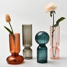 three different colored vases with flowers in them