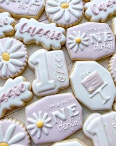 some decorated cookies are sitting on a table with white and pink frosted icing