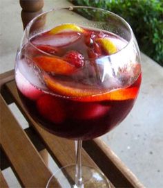 a glass filled with liquid sitting on top of a wooden table