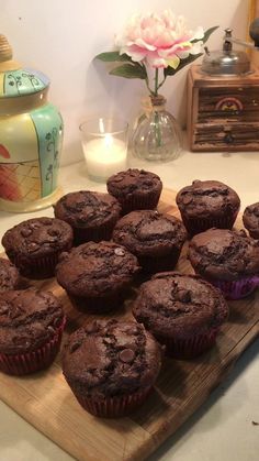 chocolate muffins sitting on a wooden cutting board