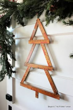 a wooden christmas tree hanging on the wall