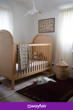 a baby crib in the corner of a room next to a rug and window