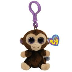 a small stuffed monkey with big eyes and a purple clip on it's back