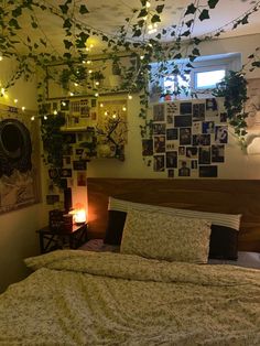 a bedroom with lights strung from the ceiling and plants growing on the wall above the bed