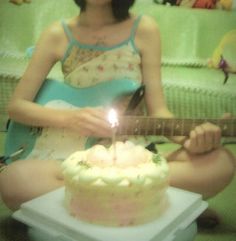 a woman sitting in front of a cake with a guitar