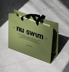 a green shopping bag with the words nu swim on it