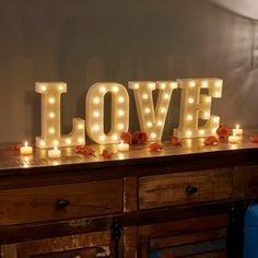 lighted letters spelling love on top of a dresser