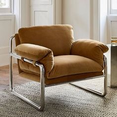 a brown chair sitting on top of a rug in a living room next to a window