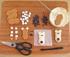 a cutting board topped with cookies, marshmallows and dog biscuits