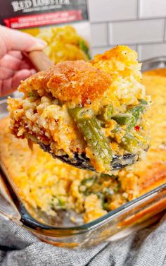 a casserole dish with broccoli and cheese being lifted from the casserole