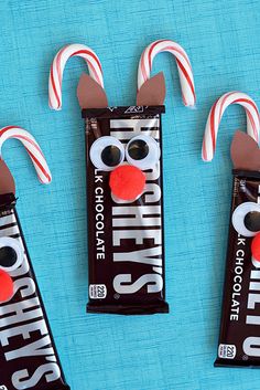 three candy bars decorated to look like rudolph the red nose reindeer with two candy canes sticking out of them