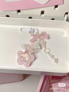 a white tray with some pink and white items on it's side, sitting next to a pair of scissors