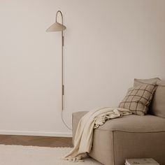 a living room with a couch, lamp and book on the floor next to it