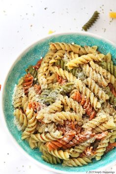 a blue bowl filled with pasta covered in sauce