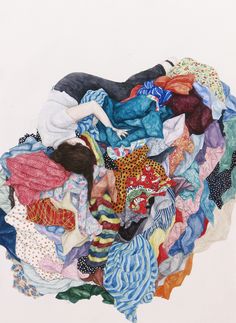 a pile of clothes sitting on top of a white floor next to a painting of a woman