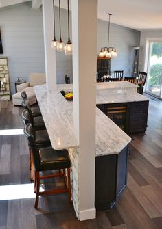 a kitchen with an island and chairs in it