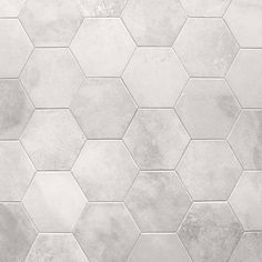 a white tile wall with hexagonal tiles on it's sides and the floor