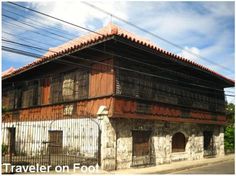 an old wooden building with iron bars on the front and sides, along with power lines in the background