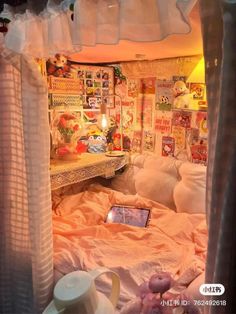 a room with a bed, desk and pictures on the wall above it that is covered in pink sheets