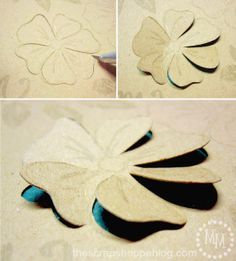 cut out paper flowers are shown with scissors