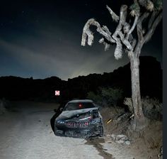 a car parked on the side of a dirt road under a night sky with stars