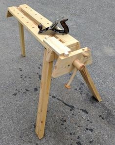 a wooden work bench sitting on top of a parking lot next to a pair of scissors