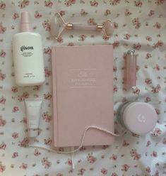 the contents of a woman's personal care kit laid out on a floral sheet