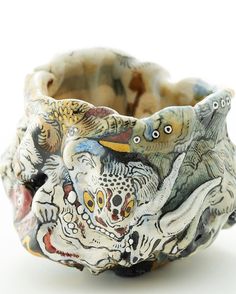 a close up of a ceramic bowl on a white surface with animals painted on it