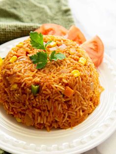 a white plate topped with rice covered in sauce and garnished with parsley