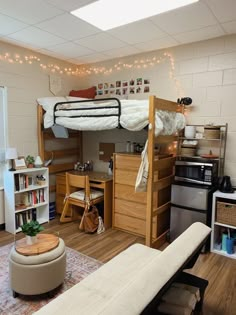 a loft bed sitting in the middle of a living room next to a desk and bookshelf