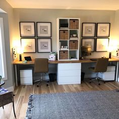 a home office with two desks and several framed pictures on the wall above it