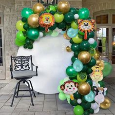 an arch made out of balloons with animals and lions on the front door for a jungle themed birthday party