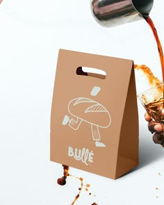 a person is pouring some liquid into a brown paper bag with a mushroom on it