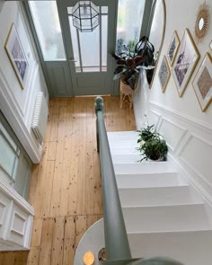 an overhead view of a staircase with potted plants on the side and pictures on the wall